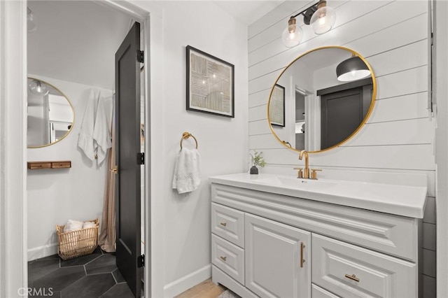 bathroom with tile patterned floors, baseboards, and vanity