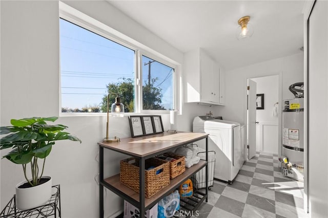 laundry area with washing machine and dryer, strapped water heater, cabinet space, and light floors