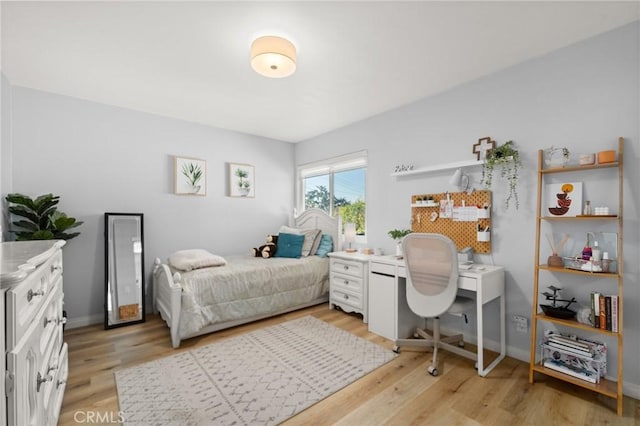 bedroom featuring baseboards and light wood finished floors