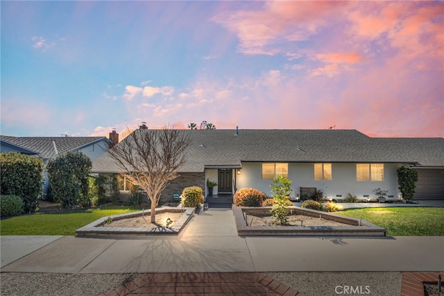 view of front of property featuring a yard, crawl space, driveway, and an attached garage