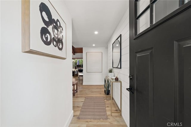 hall with light wood-type flooring, baseboards, and recessed lighting