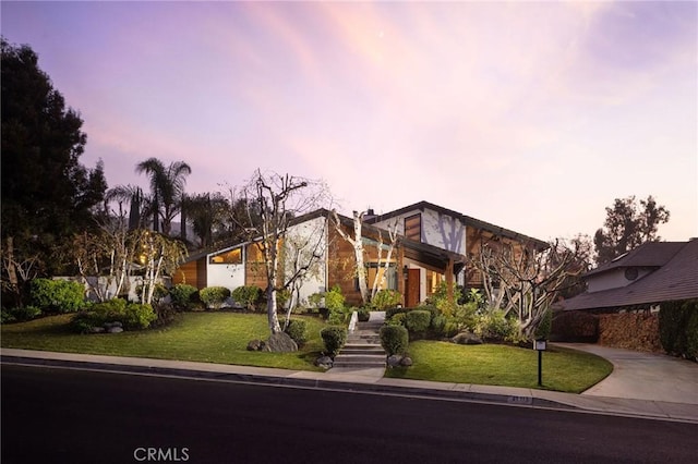 mid-century inspired home with driveway and a yard