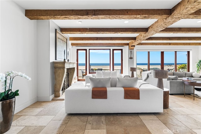 living room with beamed ceiling, stone tile flooring, and a wealth of natural light