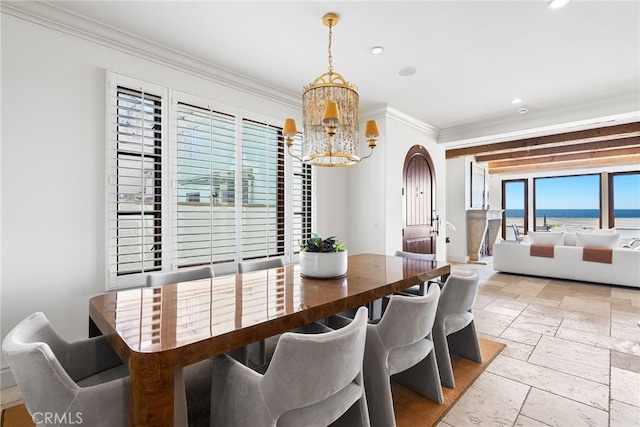 dining space featuring recessed lighting, stone tile floors, arched walkways, crown molding, and a notable chandelier