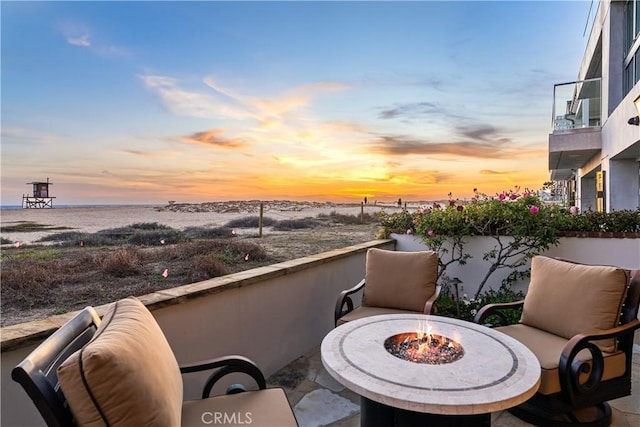 balcony with an outdoor fire pit and a water view