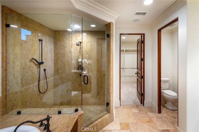 full bathroom with toilet, visible vents, a shower stall, crown molding, and a walk in closet