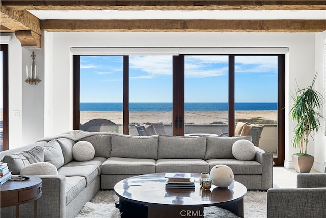 living room with a beach view, beam ceiling, and a water view