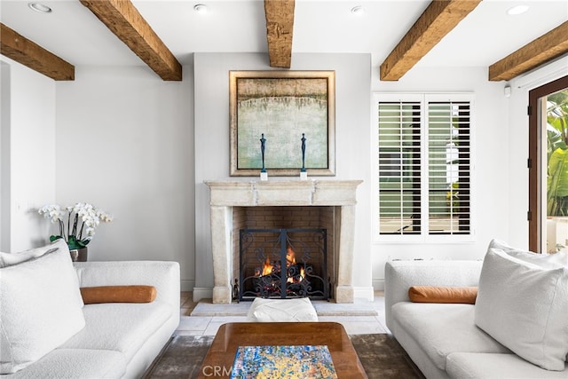 living room featuring a premium fireplace, beam ceiling, and baseboards