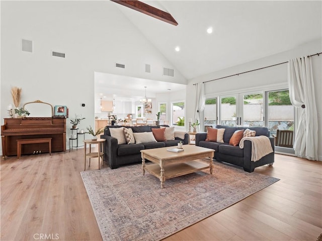 living area with light wood-style flooring, visible vents, and a notable chandelier