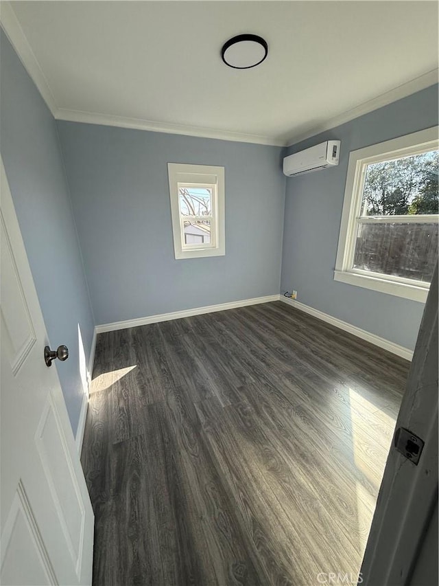 interior space featuring dark wood-type flooring, a wall mounted air conditioner, ornamental molding, and baseboards