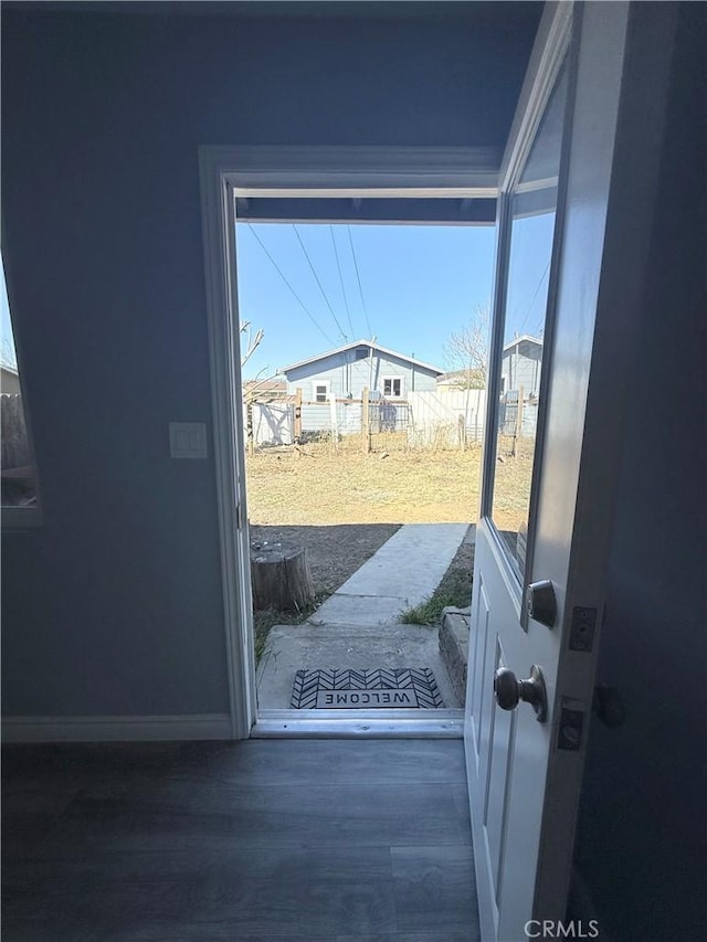 doorway to outside with baseboards and wood finished floors