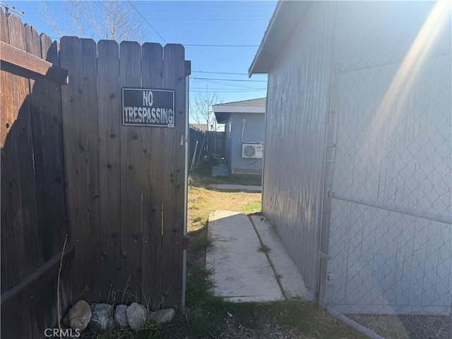 view of side of property featuring fence and a gate