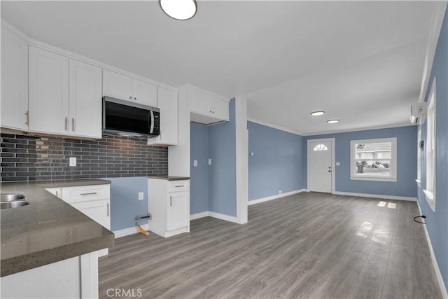 34945 Ave B, Yucaipa, CA 92399 - kitchen featuring light wood-style floors, decorative backsplash, white cabinets, and baseboards