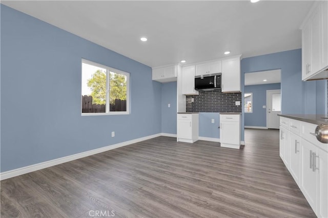 34945 Ave B, Yucaipa, CA 92399 - kitchen featuring dark wood finished floors, stainless steel microwave, white cabinets, and tasteful backsplash