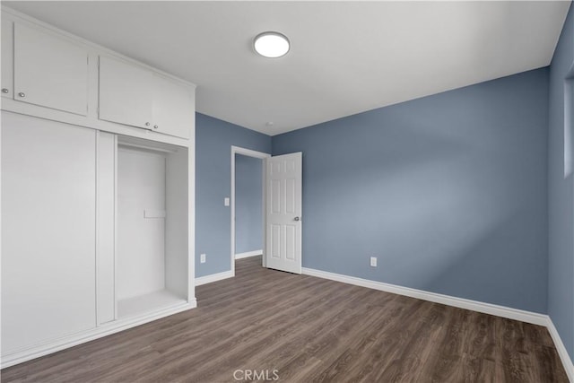 34945 Ave B, Yucaipa, CA 92399 - unfurnished bedroom with baseboards, dark wood-style flooring, and a closet