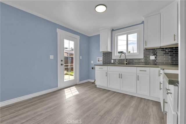 34945 Ave B, Yucaipa, CA 92399 - kitchen with backsplash, light wood-type flooring, a sink, baseboards, and white cabinets