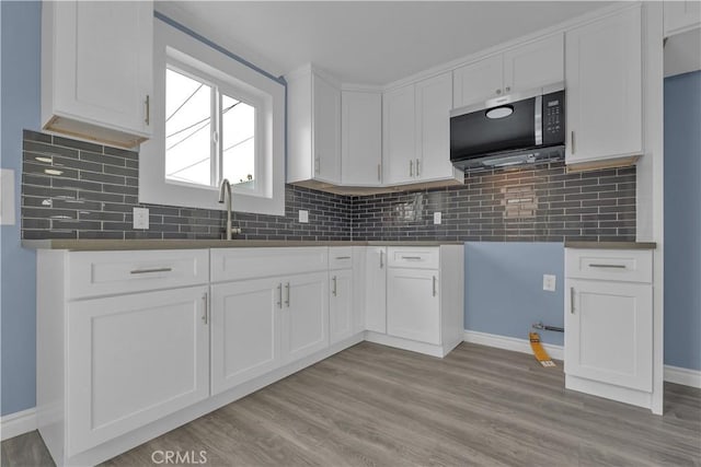 34945 Ave B, Yucaipa, CA 92399 - kitchen featuring a sink, baseboards, stainless steel microwave, and white cabinetry