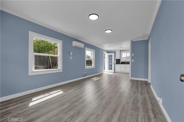 34945 Ave B, Yucaipa, CA 92399 - unfurnished living room with dark wood-type flooring, baseboards, a wall mounted AC, and a wealth of natural light