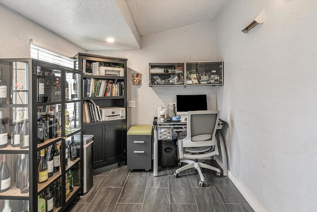 office space featuring a textured wall and baseboards