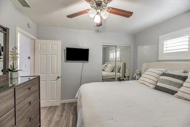 bedroom featuring visible vents, multiple windows, a closet, and light wood-style flooring