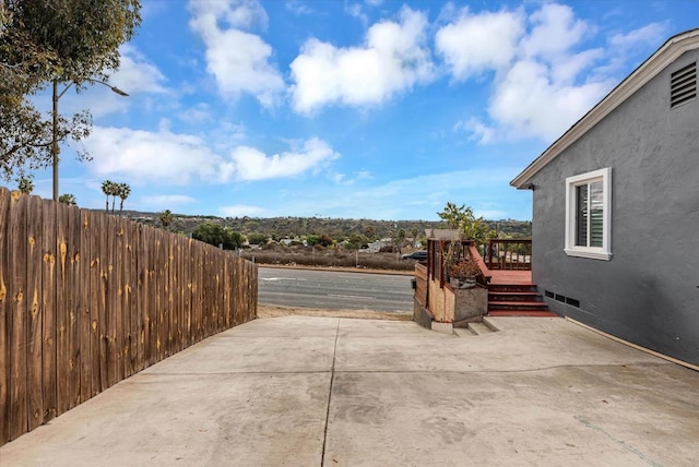 view of patio / terrace with a deck and fence