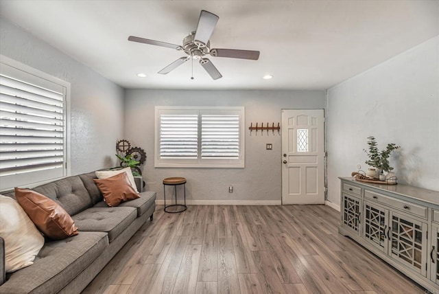 living area with a ceiling fan, recessed lighting, baseboards, and wood finished floors