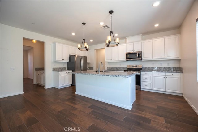 kitchen with stainless steel appliances, white cabinets, visible vents, and a sink