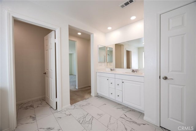 full bath featuring marble finish floor, double vanity, a sink, and visible vents