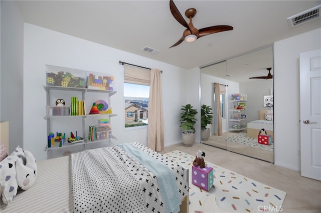 carpeted bedroom featuring a closet, visible vents, and a ceiling fan