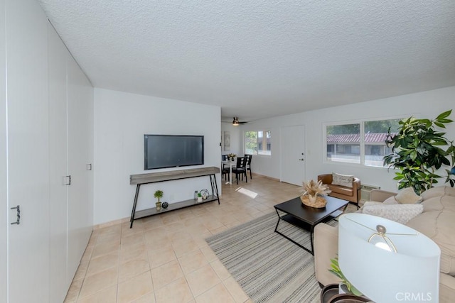 living room with a textured ceiling and light tile patterned flooring