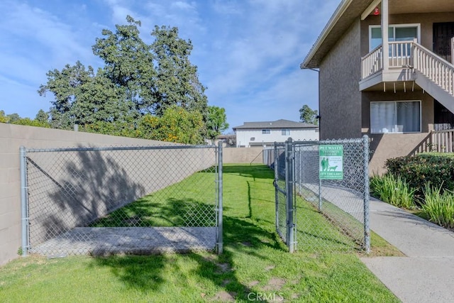 exterior space with a gate, a yard, and fence