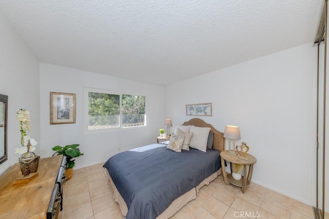 bedroom featuring a textured ceiling and light tile patterned floors