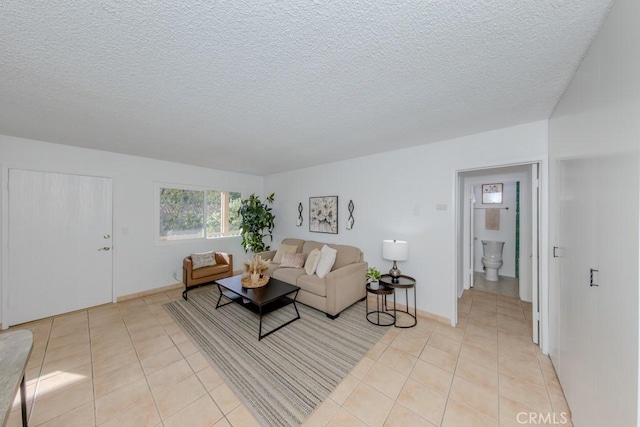 living room featuring a textured ceiling and light tile patterned floors