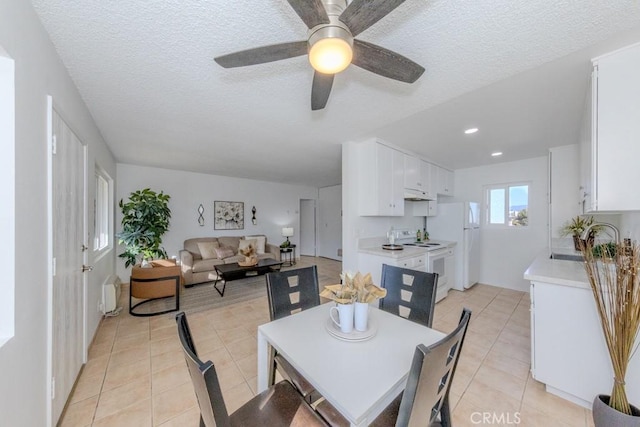 dining space featuring light tile patterned floors, a textured ceiling, and recessed lighting