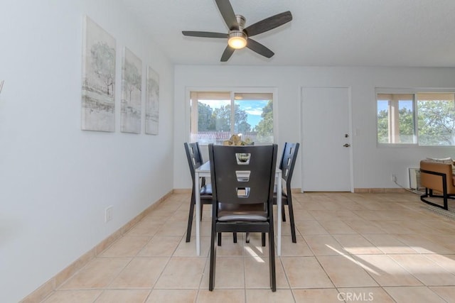 dining area with light tile patterned flooring, ceiling fan, and baseboards