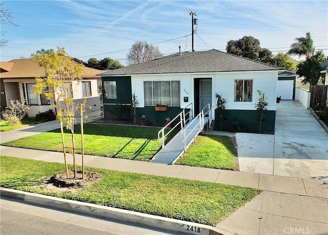 view of front of home with a front yard, stucco siding, an outdoor structure, and entry steps