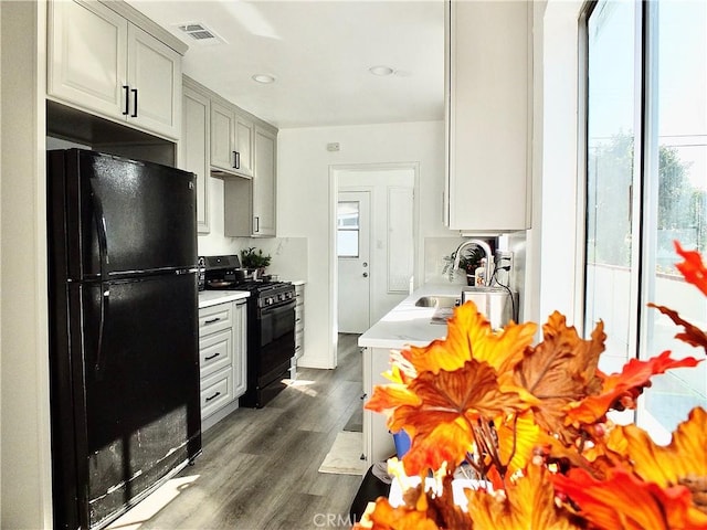 kitchen featuring black appliances, visible vents, light countertops, and a sink