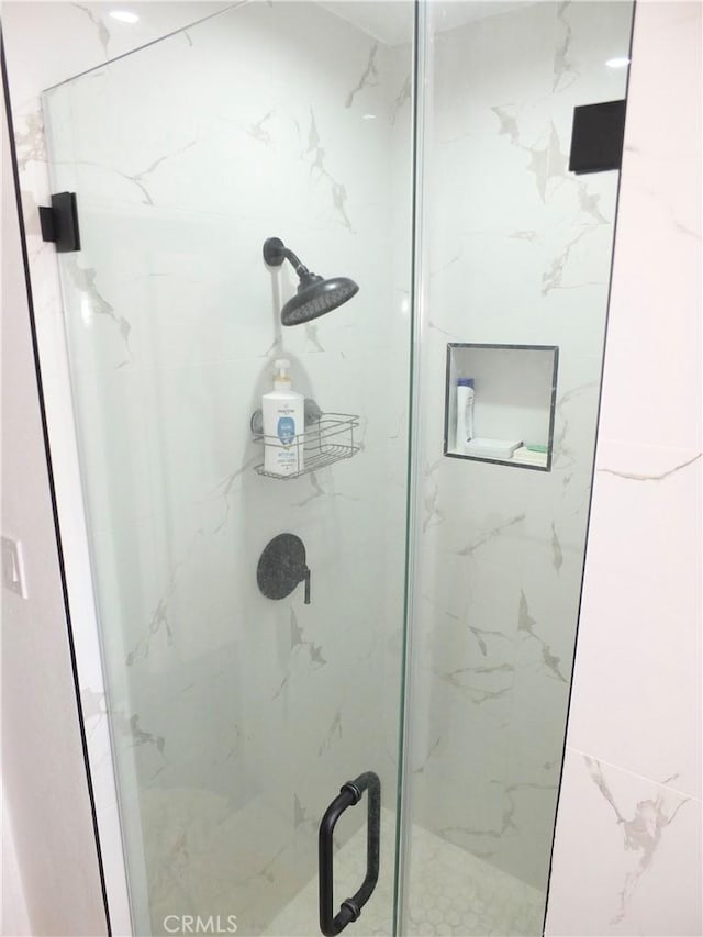 full bathroom featuring a marble finish shower