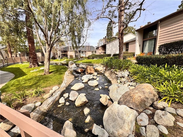 surrounding community with a residential view, fence, and a lawn