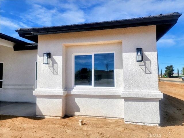 view of side of home with stucco siding