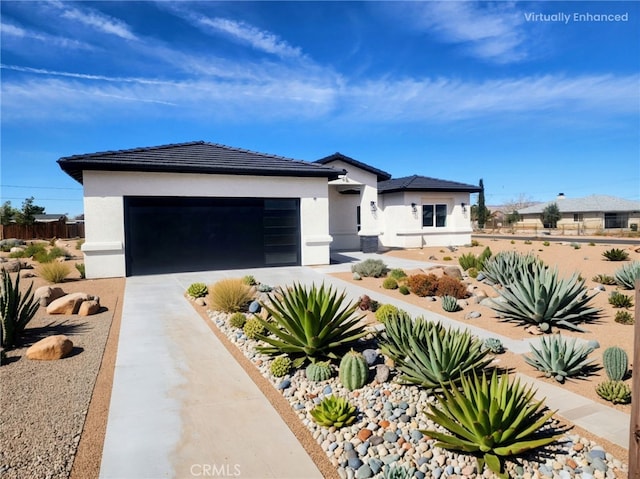 prairie-style house featuring a tiled roof, driveway, stucco siding, and an attached garage
