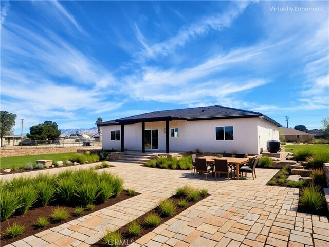 rear view of property featuring stucco siding and a patio area