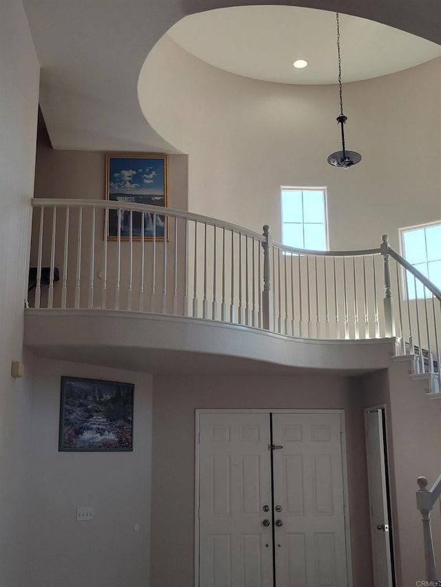 stairs with a healthy amount of sunlight and a towering ceiling