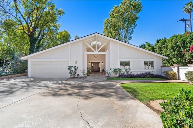 mid-century home with driveway, a front yard, an attached garage, and stucco siding