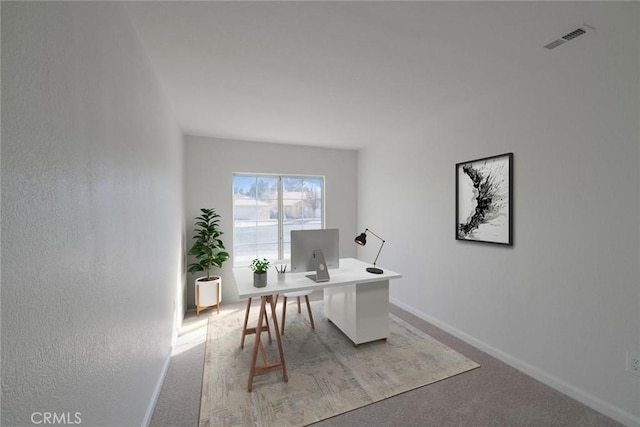 home office with visible vents, light carpet, and baseboards