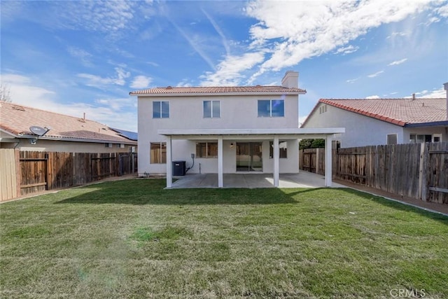 back of house featuring central AC unit, a fenced backyard, a yard, a chimney, and a patio area