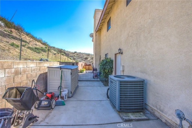 view of patio / terrace featuring fence, a mountain view, and central AC