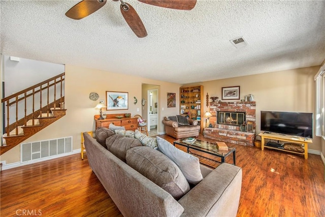 living room with stairway, wood finished floors, and visible vents