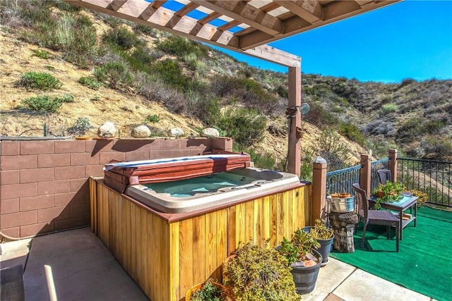 view of patio / terrace with a pergola and a hot tub