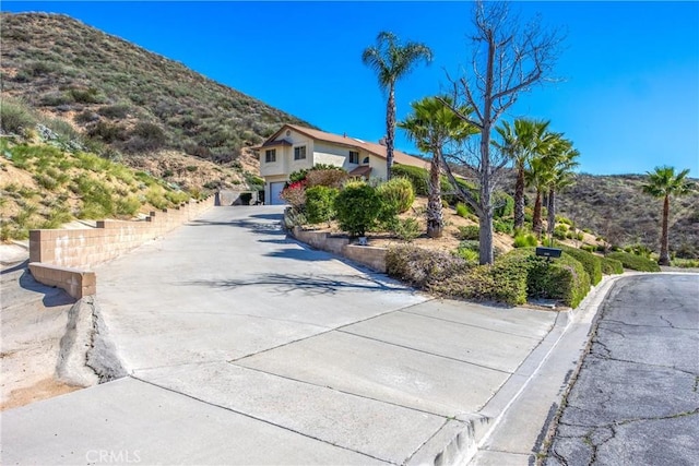 view of front of house featuring a garage, concrete driveway, and a mountain view